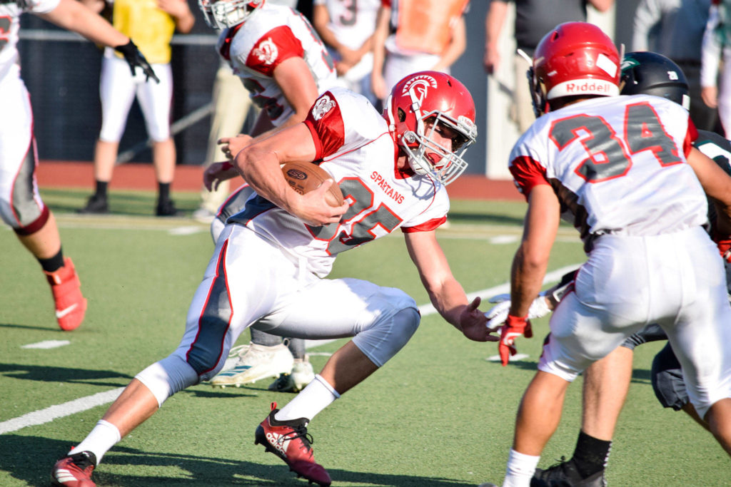 Junior running back Caden Carrigan runs through the Jackson defense on Friday at Everett Memorial Stadium. (Katie Webber / The Herald)
