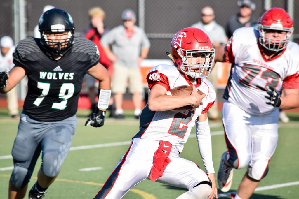 Senior quarterback Chase Norton runs with the ball against Jackson on Friday at Everett Memorial Stadium. (Katie Webber / The Herald)
