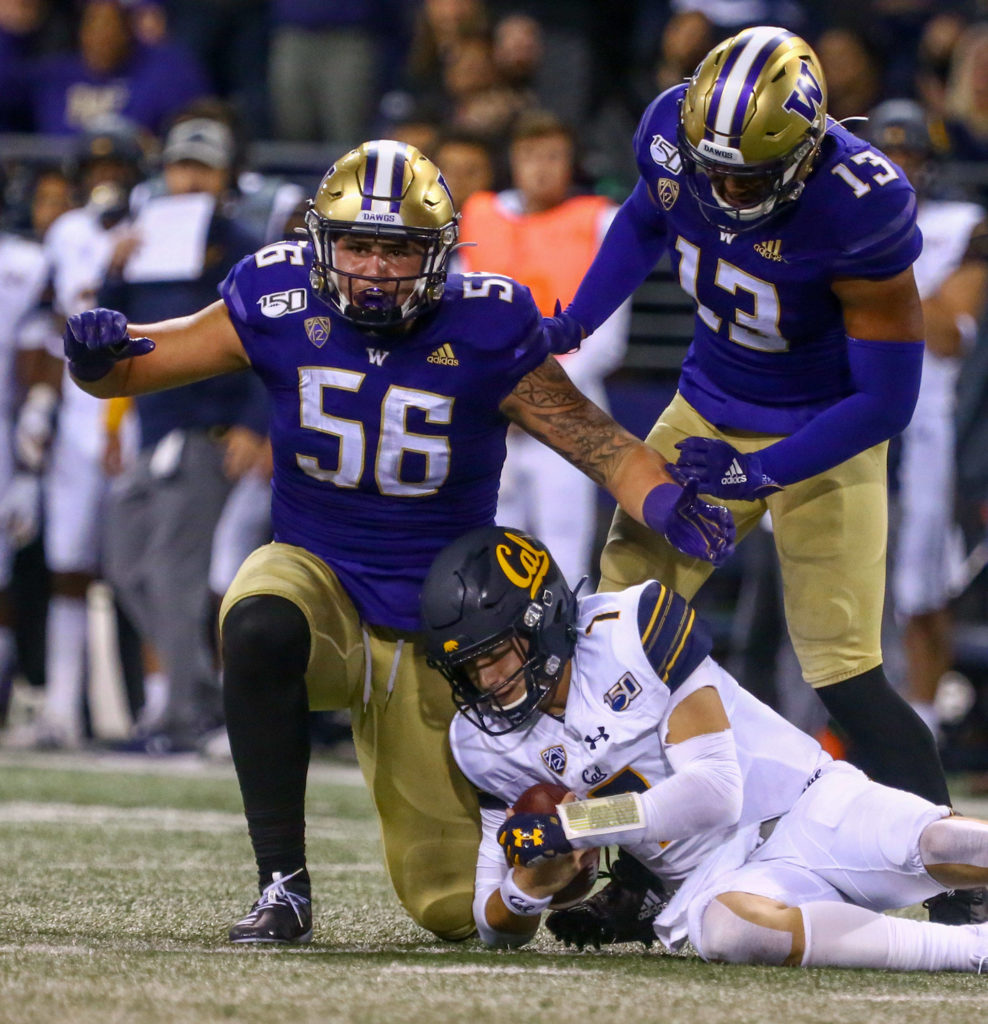 Washington’s Nick Harris celebrates his sack of California’s Chase Garbers with Washington’s Brandon Wellington (right) Saturday night at Husky Stadium in Seattle on September 7, 2019.(Kevin Clark / The Herald)