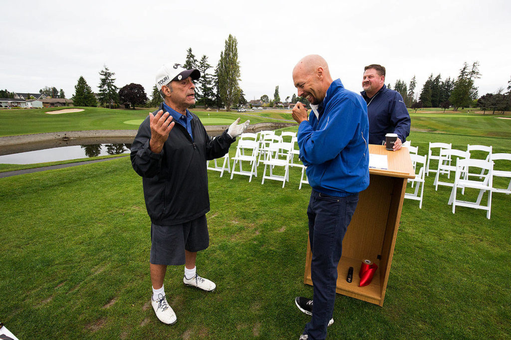 Golf course architect Todd Schoeder (right) laughs as golfer Marc Kaye (left) praises the newly renovated setup at Everett’s Legion Memorial Golf Course before a dedication ceremony Monday in Everett. The ceremony was held near the tee box of No. 14, one of the 4 new holes in the project. (Andy Bronson / The Herald)
