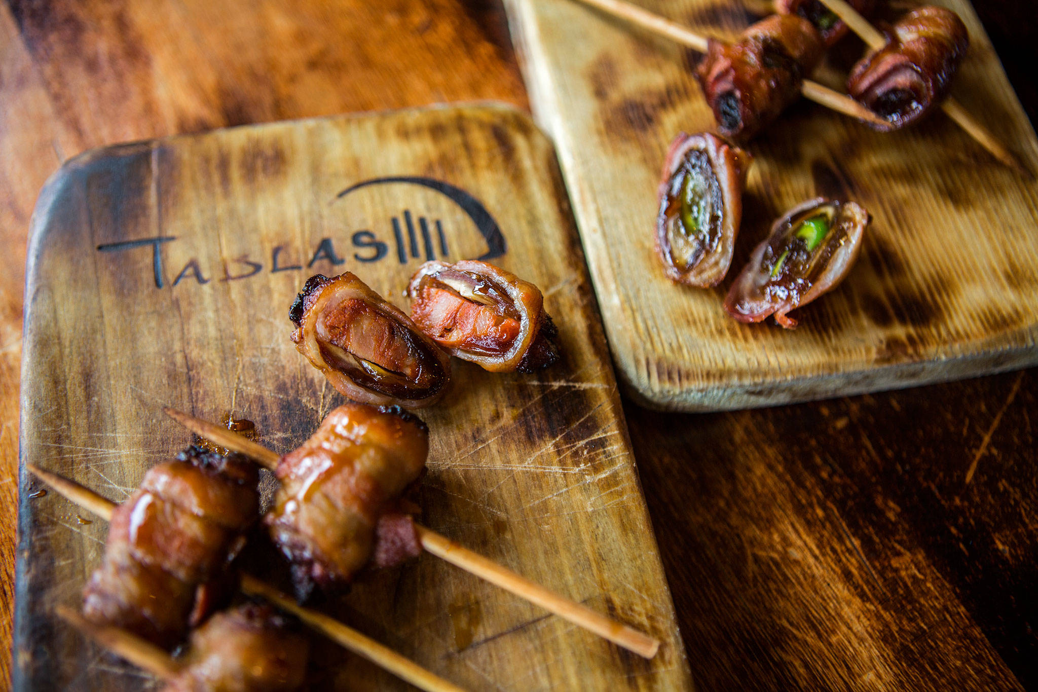 Tabla’s bacon-wrapped dates stuffed with Spanish chorizo (left) and serrano peppers. The dates also can be filled with blue cheese. (Olivia Vanni / The Herald)