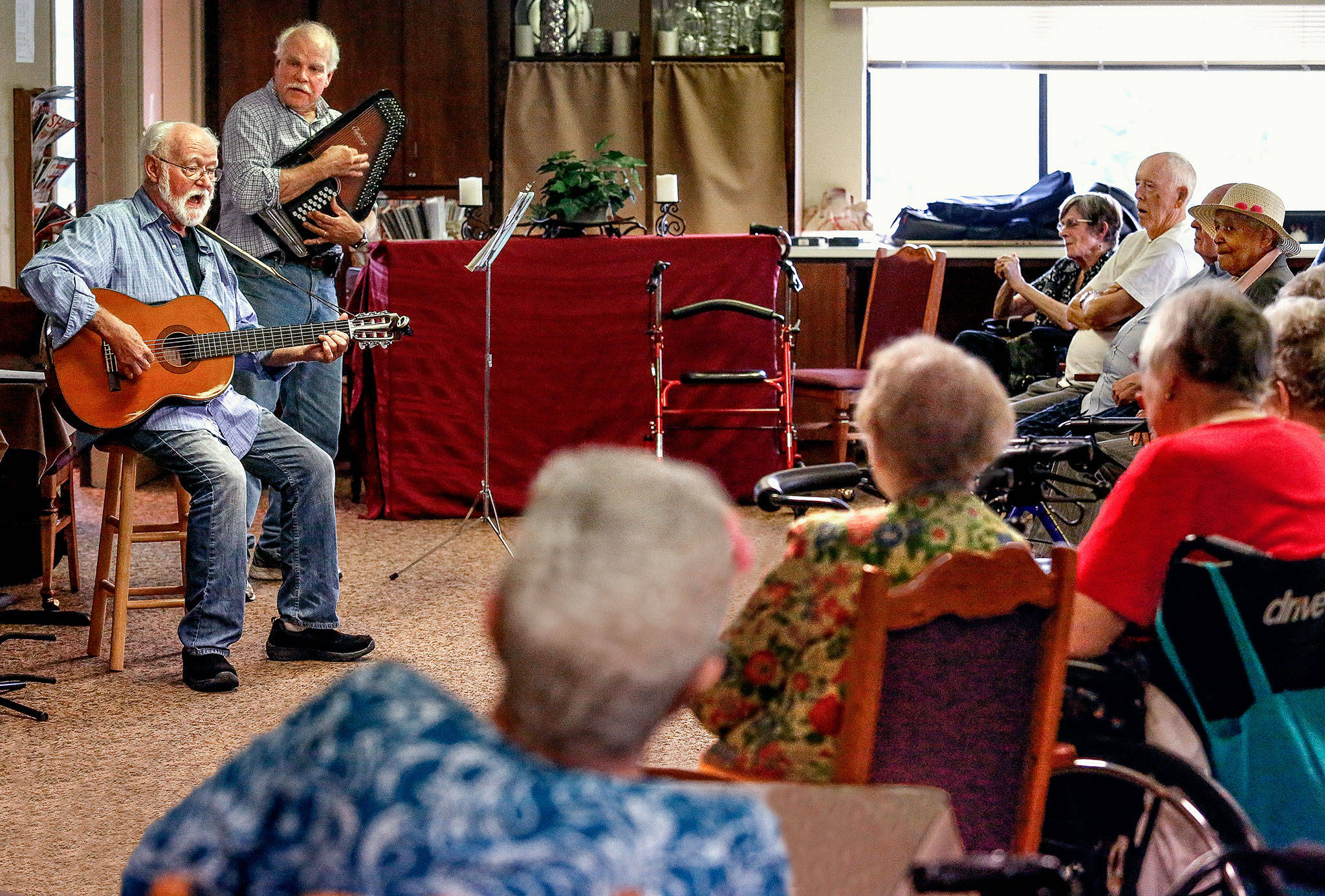 Folksingers Bob Nelson (left) and Bruce Baker perform Tuesday for residents of Sunrise View retirement community in Everett. Nelson and his wife, Judy, recently moved to Sunrise View. (Dan Bates / The Herald)