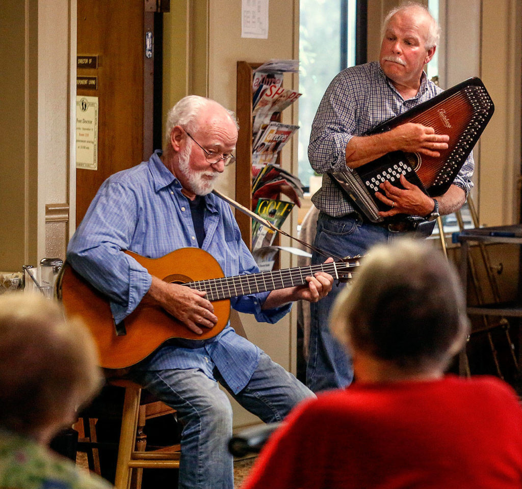 As he and Bruce Baker (on autoharp) play, Bob Nelson glances sideways to engage the audience, the residents of Sunrise View, his own neighbors. (Dan Bates / The Herald)
