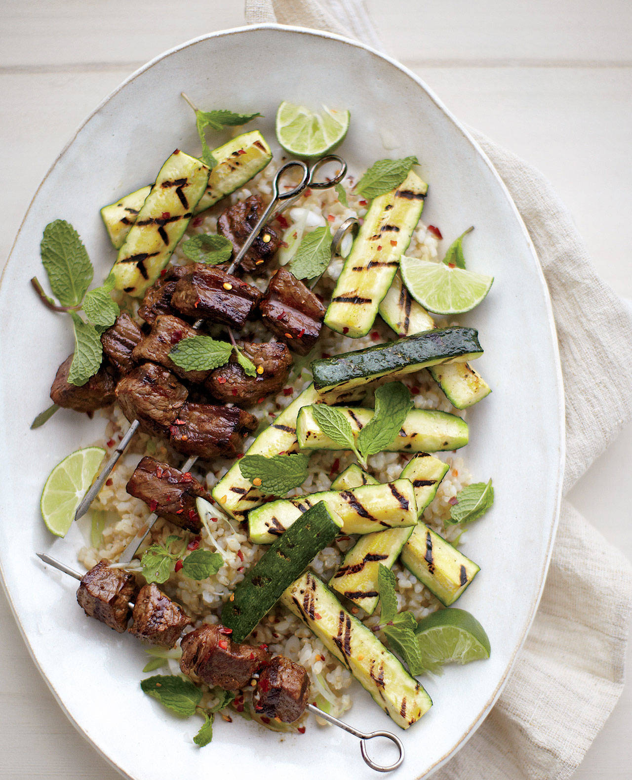 Dress sirloin-zucchini skewers with torn mint leaves and red pepper flakes. (Elizabeth Cecil)