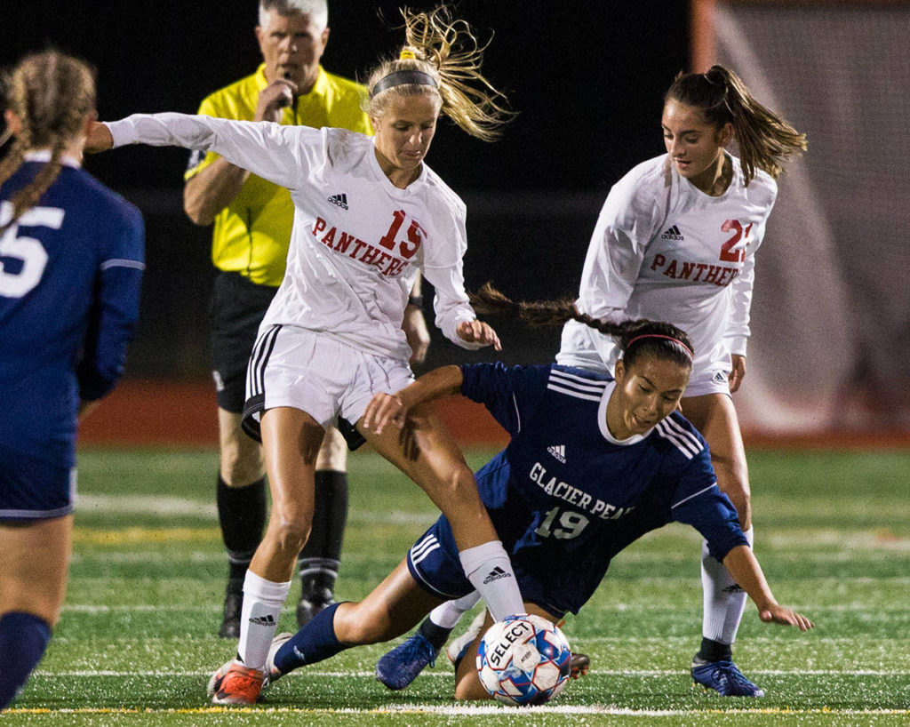 Snohomish’s Kayla Soderstrom (left) and Ravyn Mummey (right) trip up Glacier Peak’s Emily Strong (19) during a non-conference girls soccer game Tuesday at Glacier Peak High School in Snohomish. (Olivia Vanni / The Herald)

