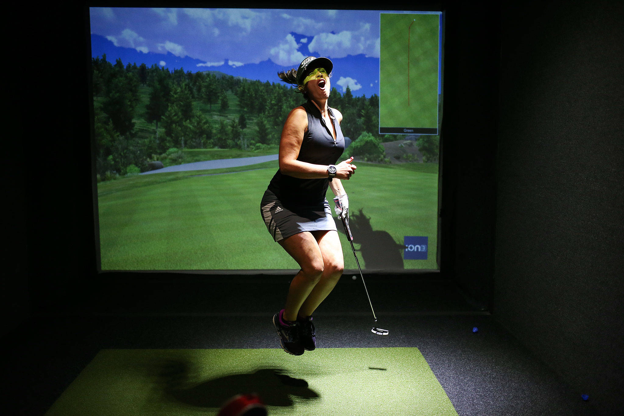 Gina Deutsch reacts to a missed putt as she and a teammate compete on the first day of Tuesday’s league play golf at Back9 Parlor in Lynnwood. (Andy Bronson / The Herald)