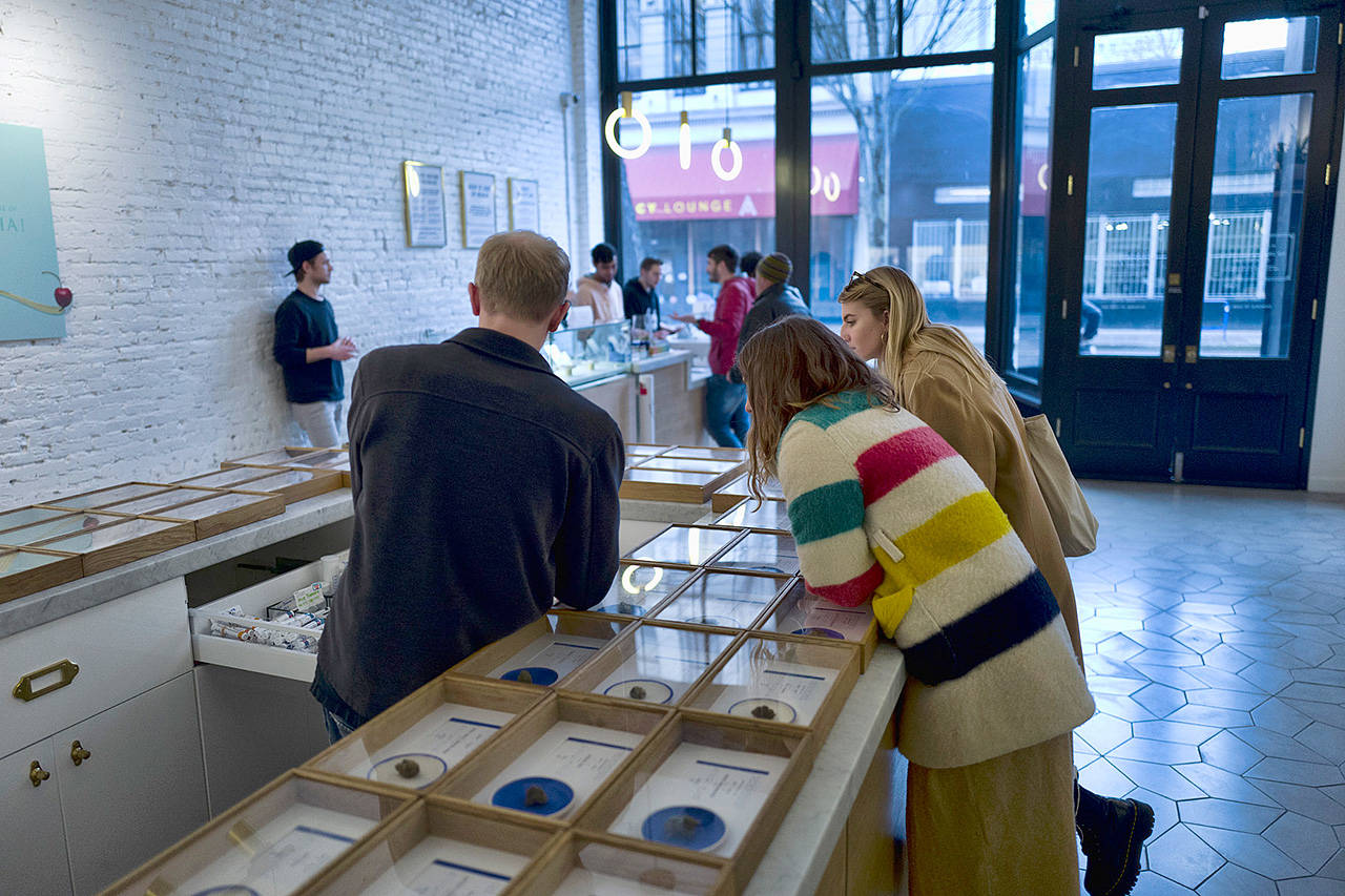 A bud tender helps customers at a dispensary in Portland, Oregon. In the wake of lung illnesses and deaths related to vaping, Oregon will ask its legal marijuana retailers to review the cannabis products on their shelves and voluntarily hold or pull those that they don’t feel confident about. (Associated Press file)