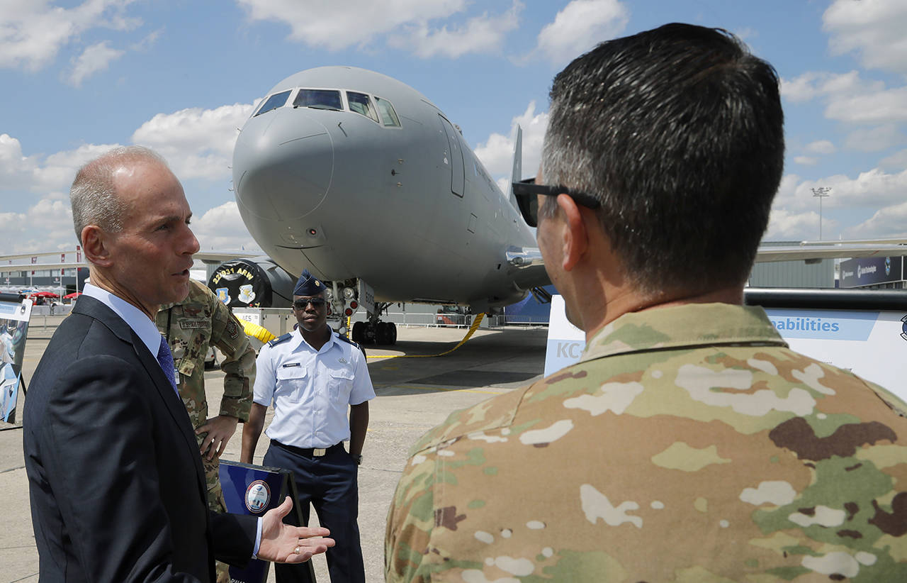 Boeing Chief Executive Dennis Muilenburg speaks to a crew member of a Boeing KC-46 taker at the Paris Air Show, in Le Bourget, east of Paris, France, on June 17. (AP Photo/Michel Euler, file)