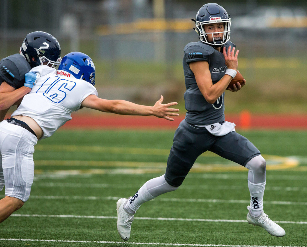 Meadowdale’s Hunter Moen escapes a tackle during a game against Shorewood on Sept. 13, 2019, at Edmonds Stadium. (Olivia Vanni / The Herald)
