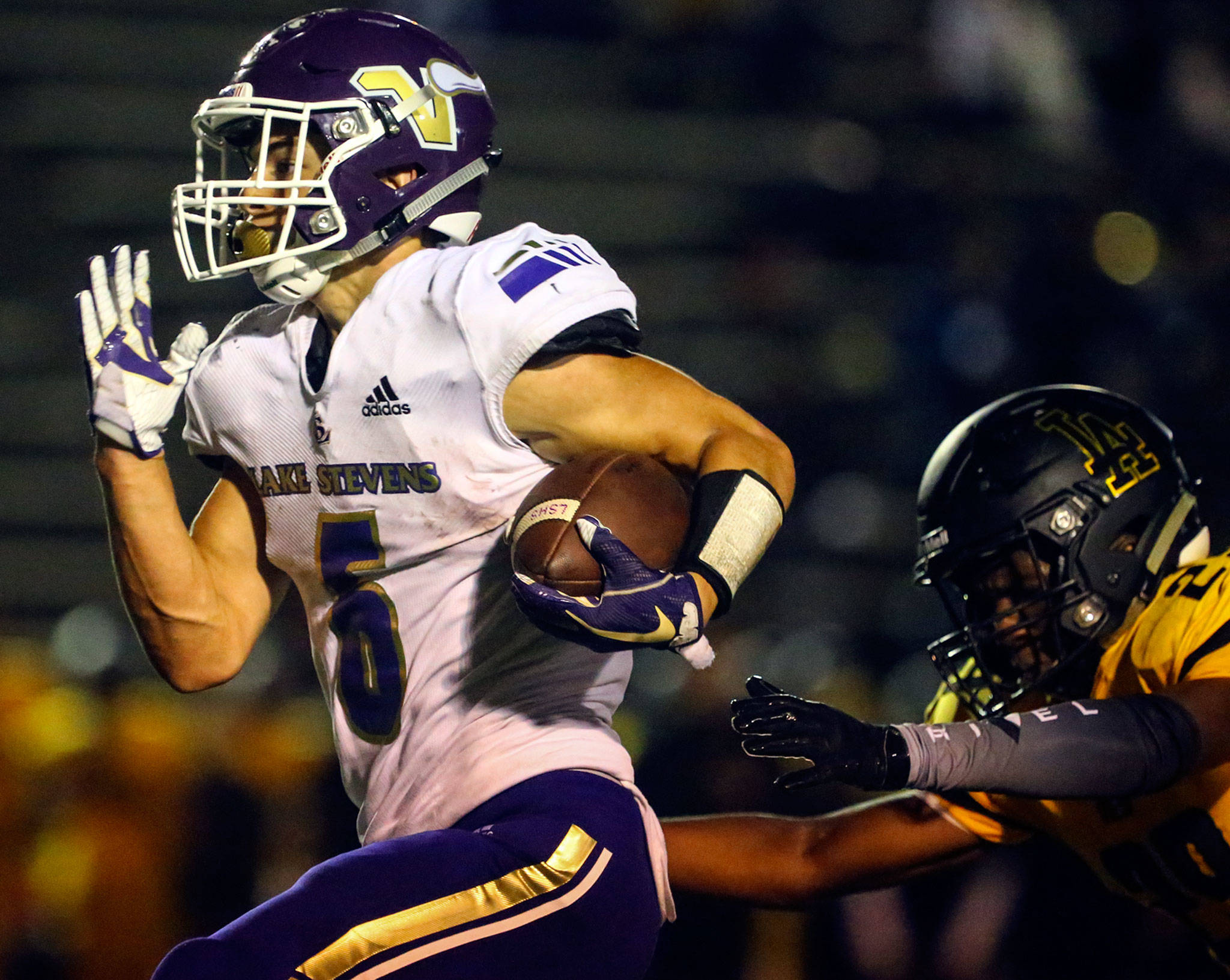 Lake Stevens’ Dallas Landeros outruns Lincoln’s Amarian Culpepper during a game on Sept. 13, 2019, at Lincoln Bowl in Tacoma. Lake Stevens won 35-26. (Kevin Clark / The Herald)