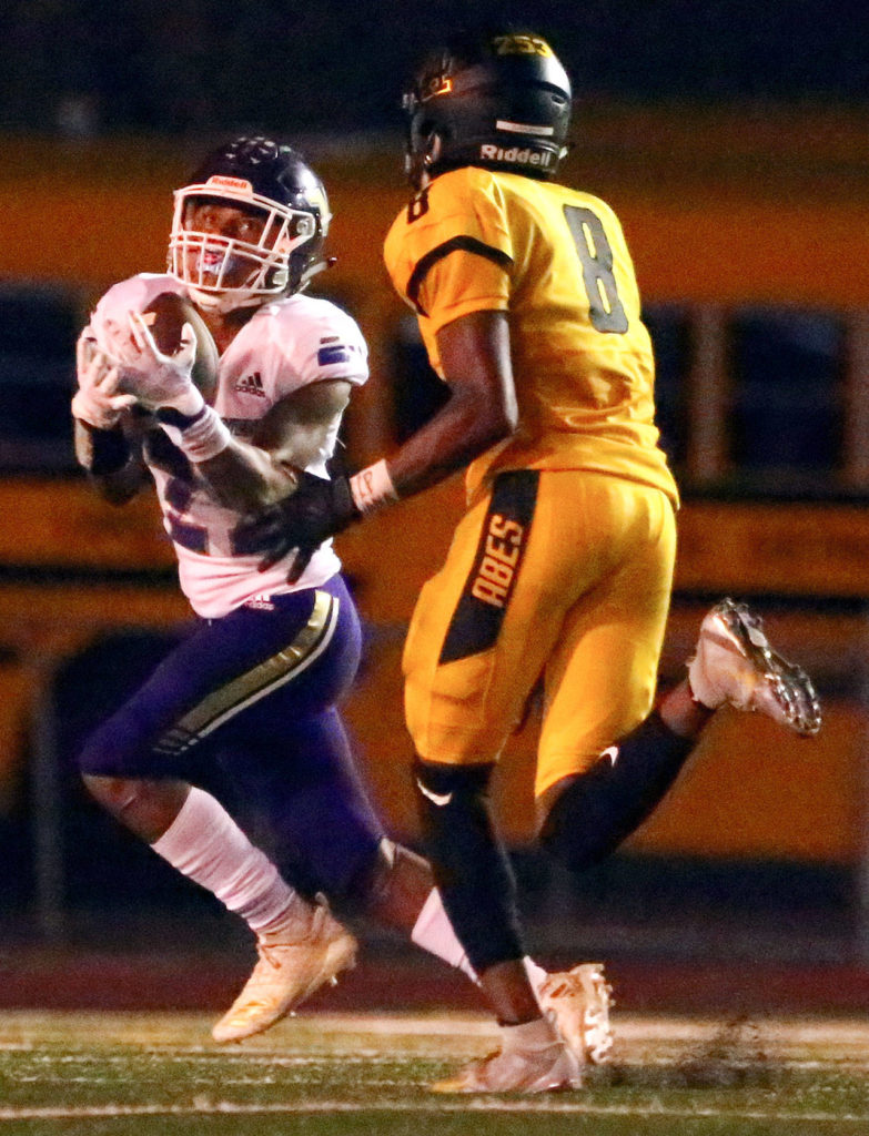 Lake Stevens’ Kasen Kinchen (left) makes a reception over Lincoln’s Jaylen Clark during a game on Sept. 13, 2019, at Lincoln Bowl in Tacoma. Lake Stevens won 35-26. (Kevin Clark / The Herald)
