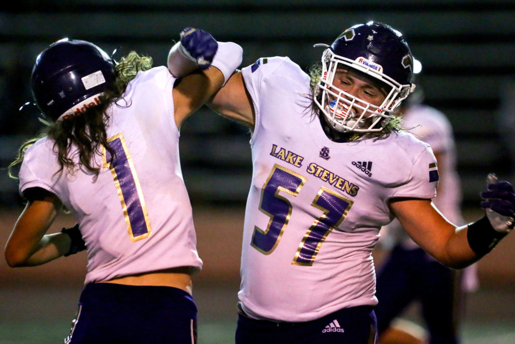 Lake Stevens’ Gabe Ramsey (left) and Austyn Rembold-Hyde celebrate during a game against Lincoln on Sept. 13, 2019, at Lincoln Bowl in Tacoma. Lake Stevens won 35-26. (Kevin Clark / The Herald)
