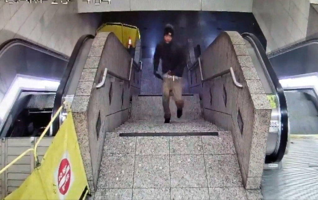 In this Friday night ecurity camera video released by the Seattle Police Department, a suspect runs upstairs after a shooting at Westlake Station for Link light rail in Seattle. The video posted to the department’s Twitter feed shows the man trying to conceal the gun near his waist as he runs up the stairs toward an exit at the station. The escalator going up, seen at left, was out of order. (Seattle Police Department via AP)

