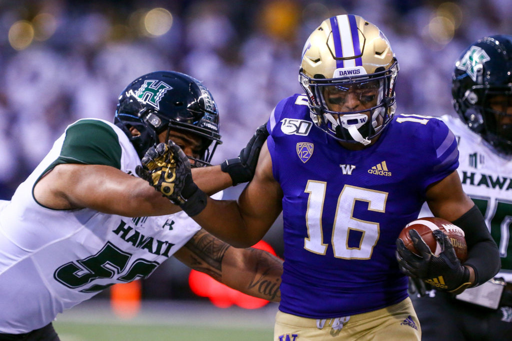Washington Cameron Williams is pushed out of bounds by Hawai’i’s Michael Boyle after an interception Saturday evening at Husky Stadium in Seattle on September 14, 2019. Husky won 52-20. (Kevin Clark / The Herald)
