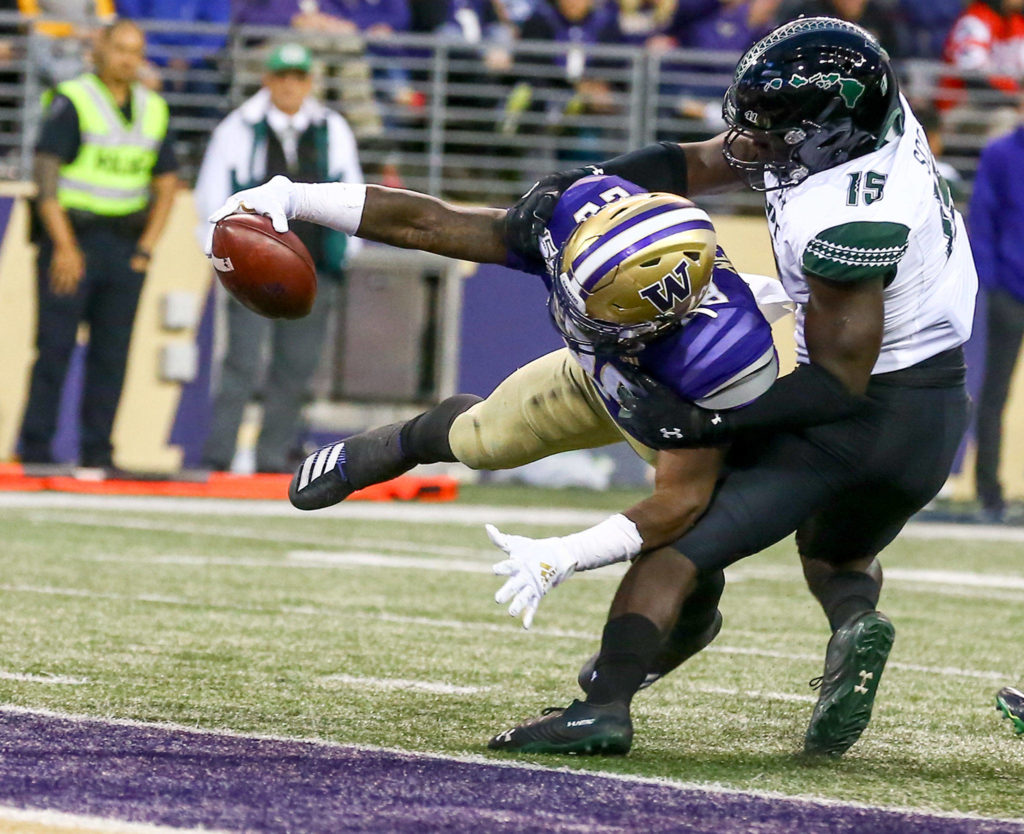 Washington’s Richard Newton reach for the goal line and a touchdown with Hawai’i’s Jonah Panoke Saturday evening at Husky Stadium in Seattle on September 14, 2019. Husky won 52-20. (Kevin Clark / The Herald)
