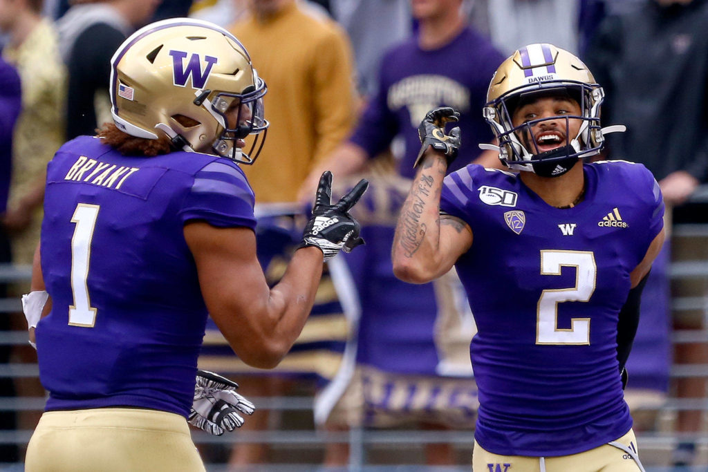 Washington’s Hunter Bryant (left) celebrates Aaron Fuller’s touchdown Saturday evening at Husky Stadium in Seattle on September 14, 2019. Husky won 52-20. (Kevin Clark / The Herald)
