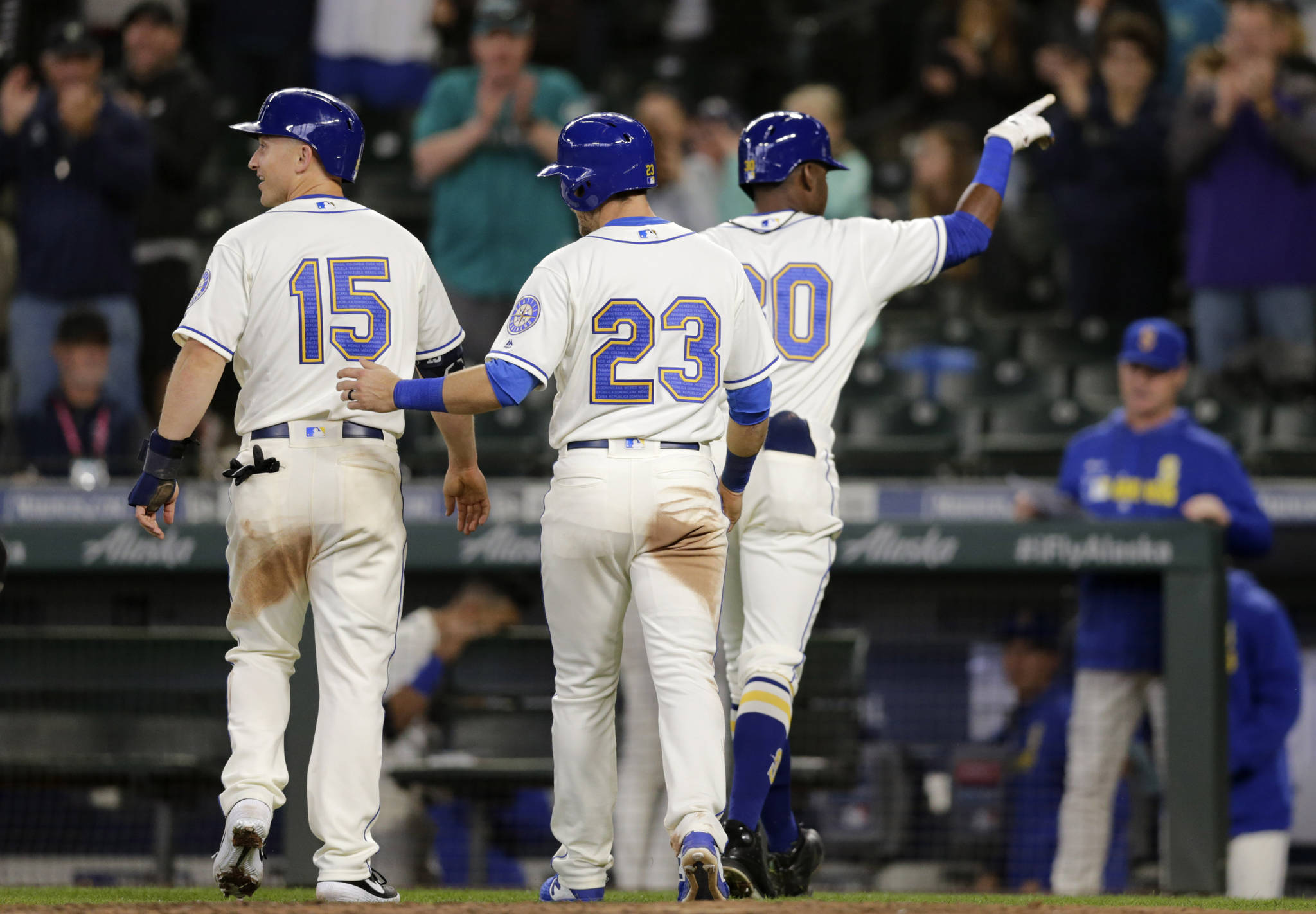 Kyle Lewis (30) points to the crowd after driving in Kyle Seager (15) and Austin Nola (23) with a home run in the eighth inning of Sunday’s game against the Chicago White Sox. (AP Photo/John Froschauer)