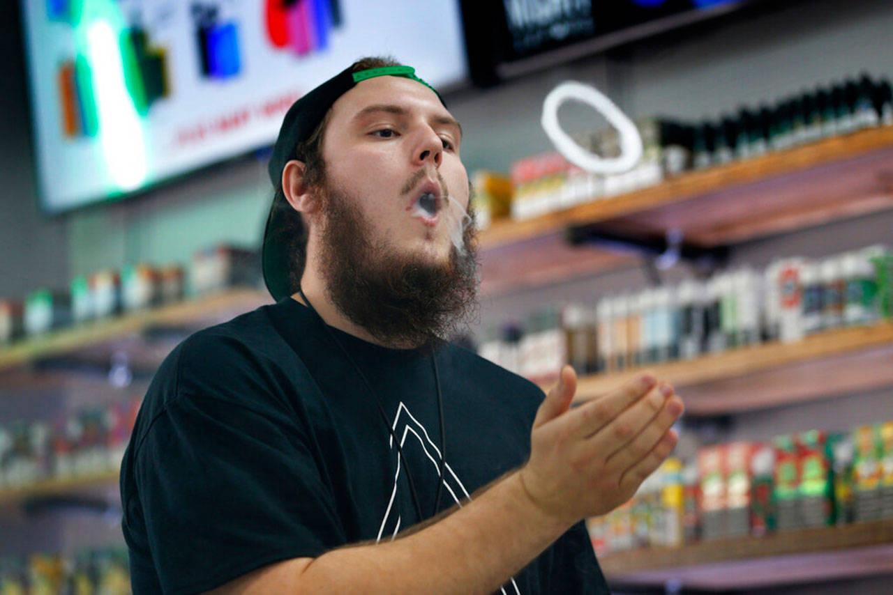 Devin Lambert, the manager at Good Guys Vape Shop, blows a vapor ring while using an e-cigarette in Biddeford, Maine, on Sept. 3. A proposed ban on flavors by the Food and Drug Administration that President Trump outlined Sept. 11, would supersede any state inaction and includes a ban on mint and menthol. (Robert F. Bukaty / Associated Press)