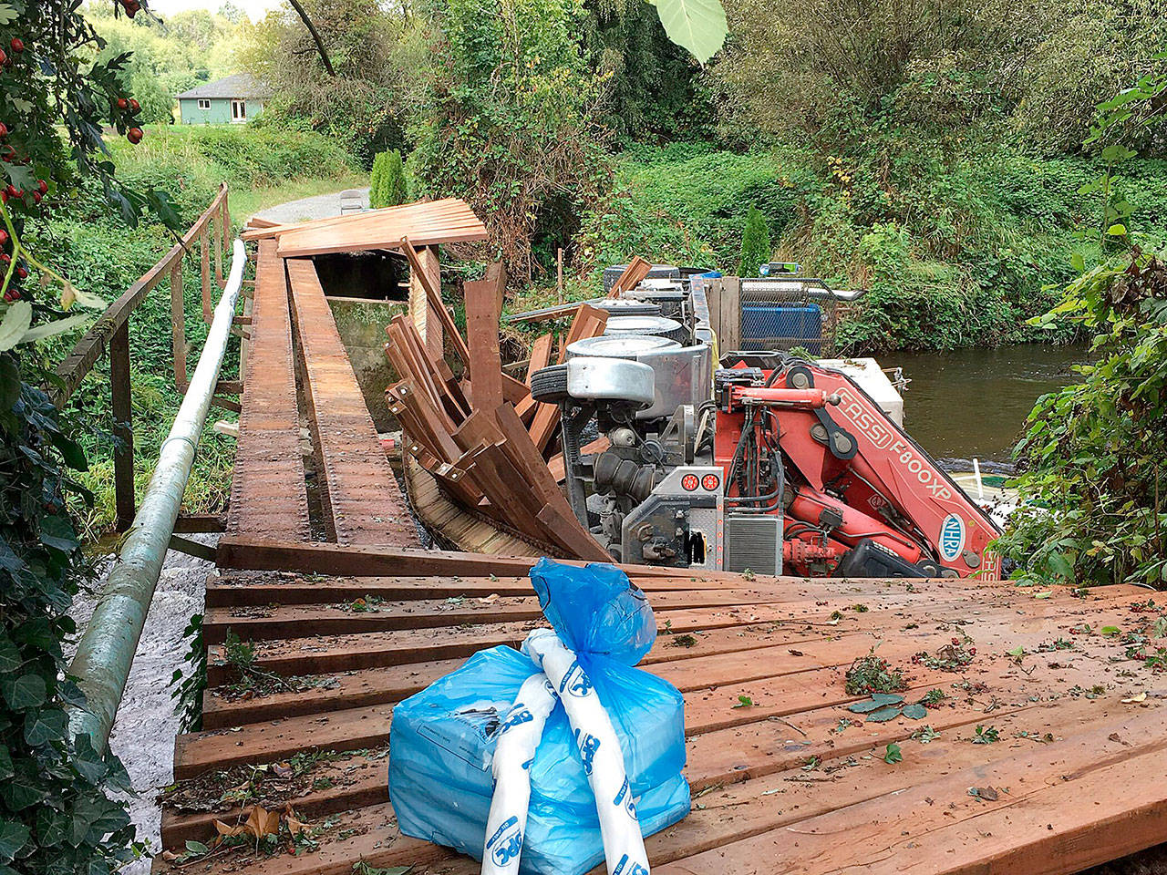 A private bridge over Woods Creek near Monroe collapsed Monday. The driver of a truck that toppled into the water was not injured. (Snohomish County Fire District 7)