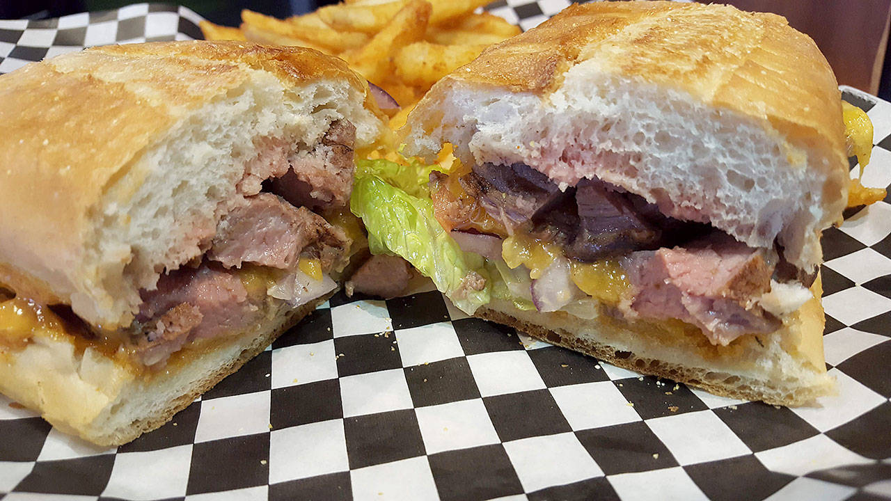 Back9 Parlor’s flank steak sandwich is made with cheddar cheese, lettuce, tomato, onion and chipotle mayo served on toasted ciabatta. (Evan Thompson / The Herald)