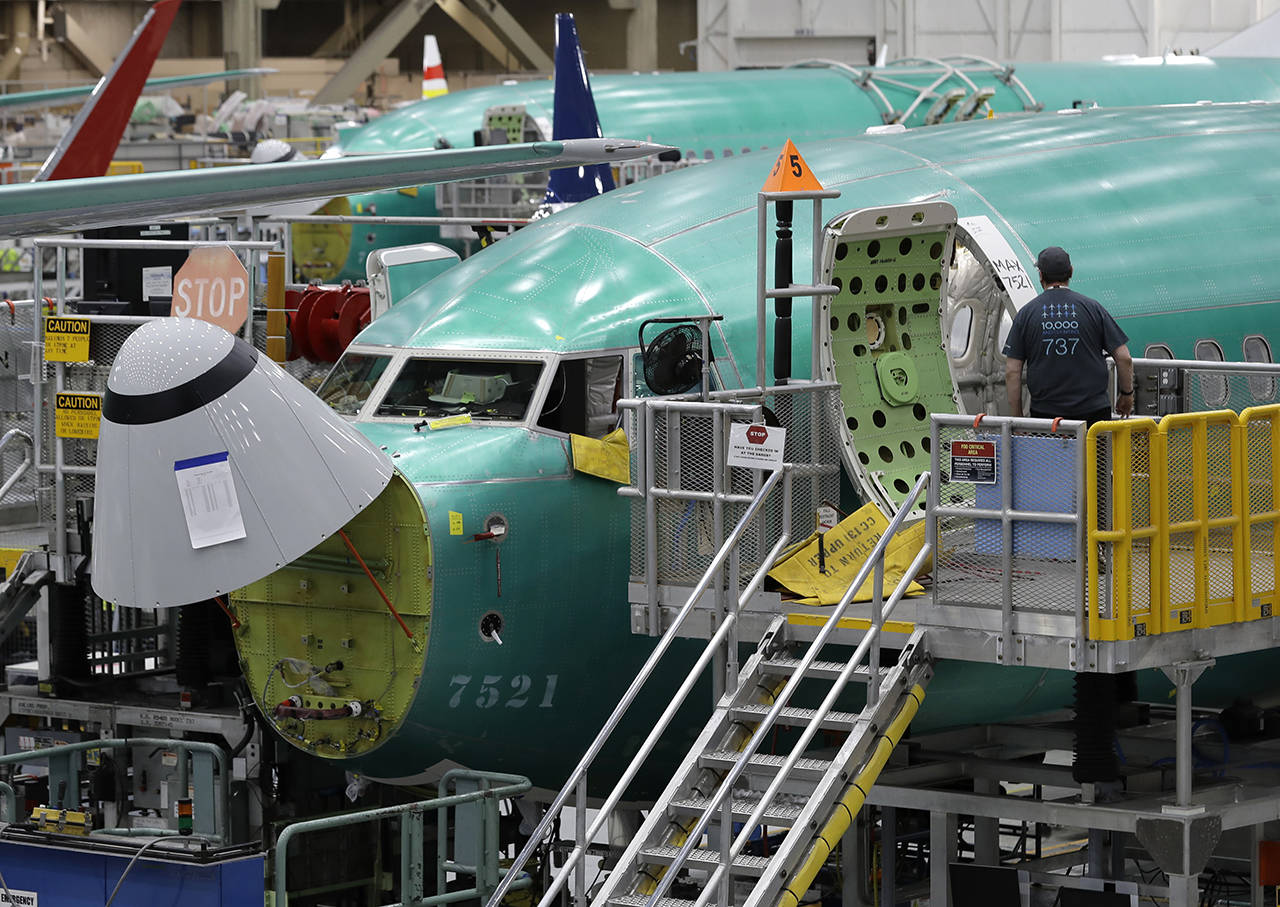 A worker enters a Boeing 737 MAX 8 airplane during a brief media tour of Boeing’s 737 assembly facility in Renton last March. (AP Photo/Ted S. Warren)
