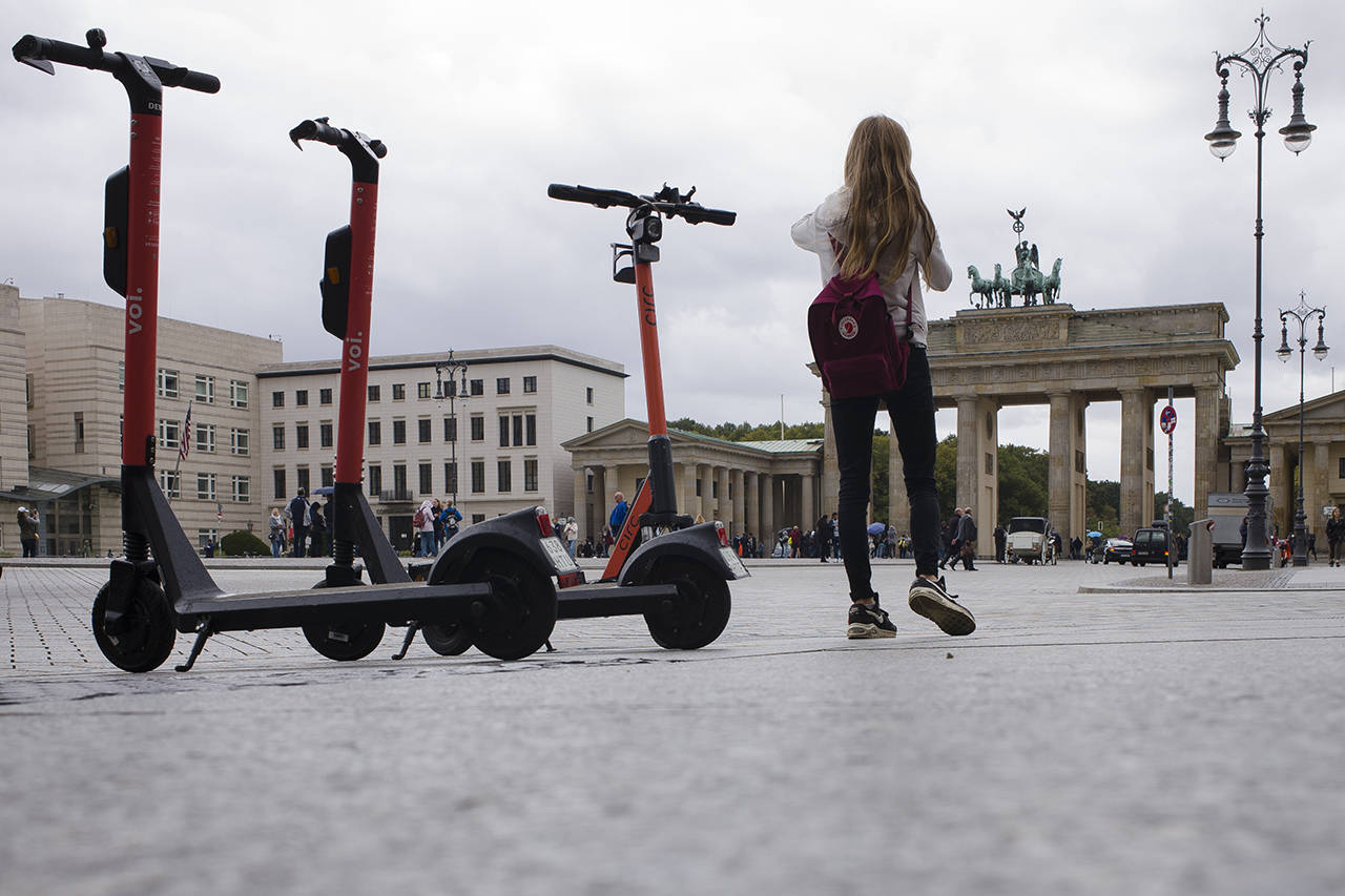 Electric scooters stand in front of the Brandenburg Gate and wait for customers in Berlin, Germany, on Tuesday. (AP Photo/Markus Schreiber)