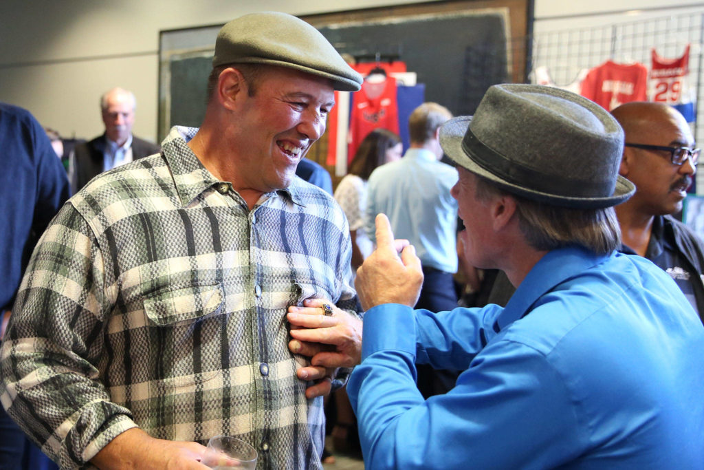 Roger Huntley (left) and Brent Summers share a laugh during the 10th Annual Snohomish County Sports Hall of Fame Banquet Wednesday evening at Angel of the Winds Arena in Everett. (Kevin Clark / The Herald)
