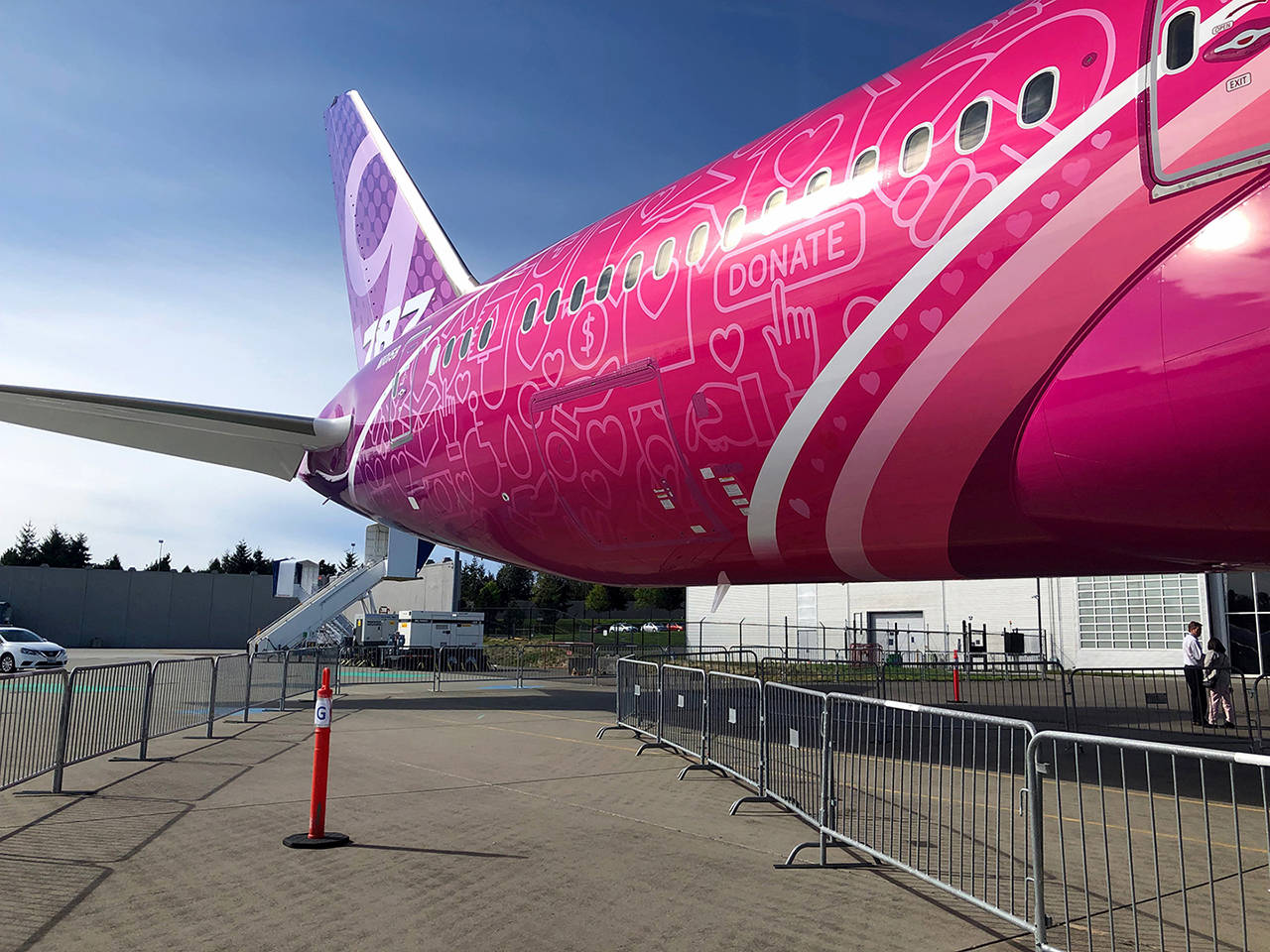 Boeing decorated a 787 Dreamliner to celebrate its Employees Community Fund. Signs and symbols of giving are displayed on a pink and purple decal that’s applied like wallpaper to the airplane. The decal is specifically designed to adhere to the 787 Dreamliner, nearly half of which is made of composite materials. (Janice Podsada / The Herald)