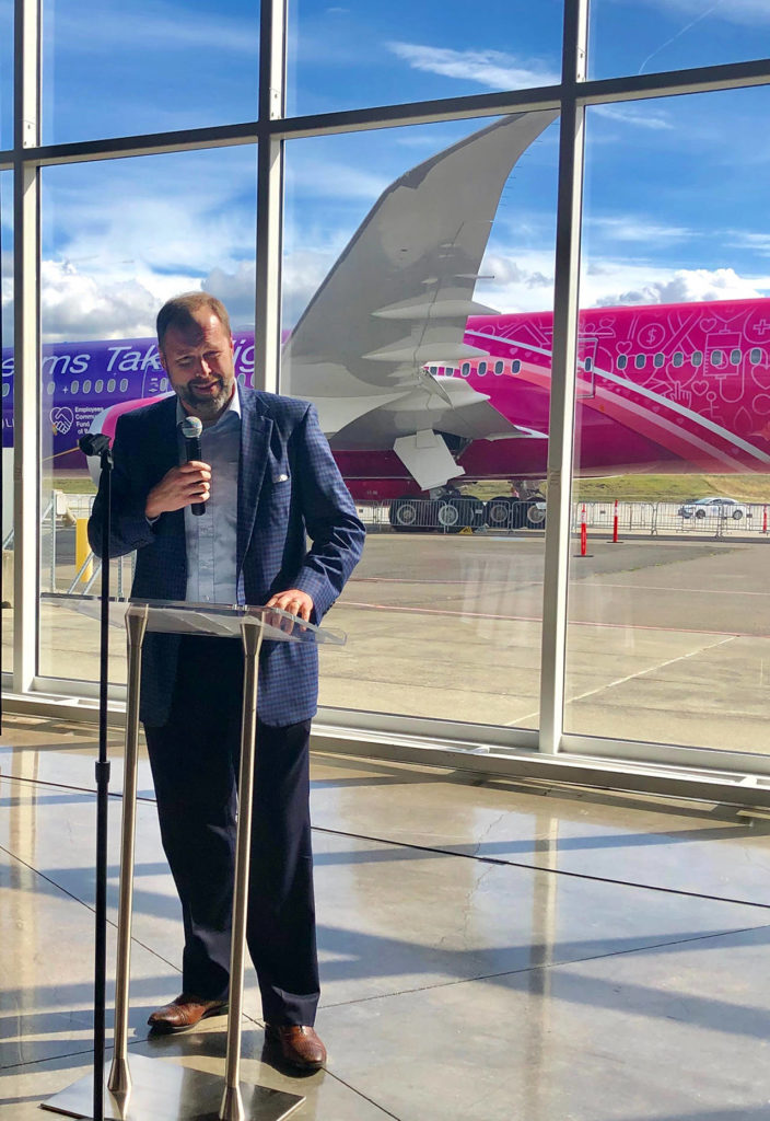 Bill McSherry, vice president of government operations commercial airplanes at the Boeing Co., welcomes Boeing workers and community leaders at a celebration of the Employees Community Fund of Puget Sound. About 100 attended the event held Thursday at the Boeing Future of Flight Aviation Center in Mukilteo. (Janice Podsada / The Herald)
