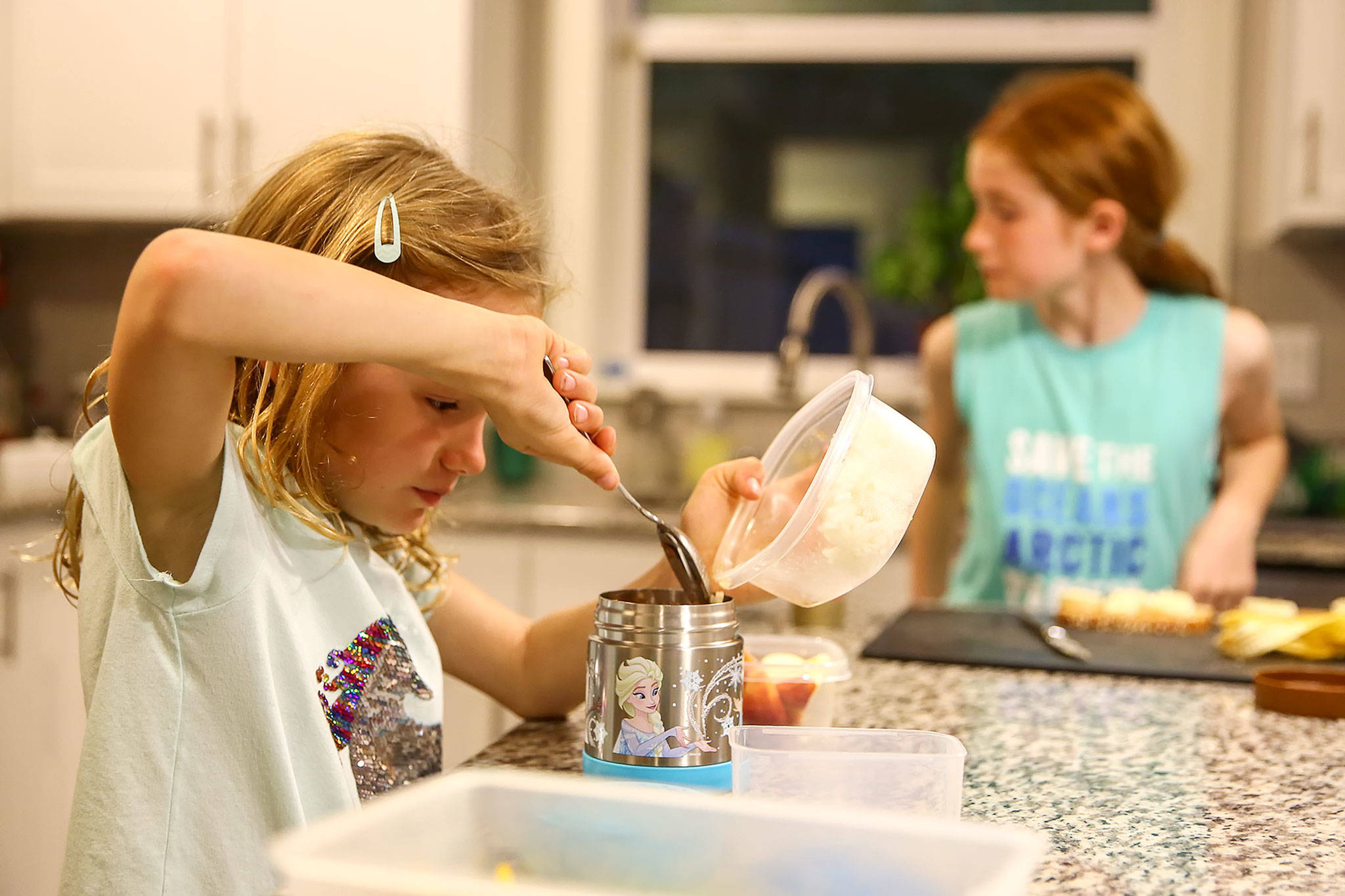 Olivia (left) and Mallory Banfield, 7 and 10, make their lunches for school Tuesday night at their home in Mukilteo. (Kevin Clark / The Herald)
