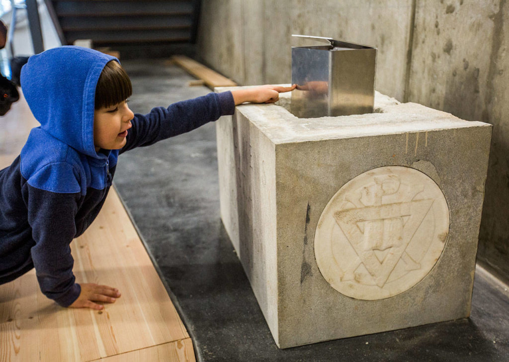 Bryan Rourke, 5, touches the new time capsule after it was placed into it’s new location during the YMCA’s time capsule ceremony on Saturday, Sept. 21, 2019 in Everett, Wash. (Olivia Vanni / The Herald)
