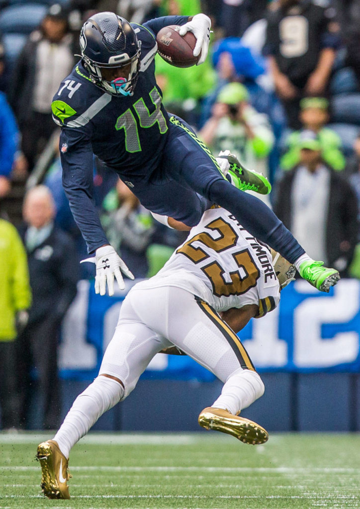 Seattle’s DK Metcalf jumps over New Orleans’ Marshon Lattimore on Sunday during the game against the New Orleans Saints at CenturyLink Field in Seattle. (Olivia Vanni / The Herald)
