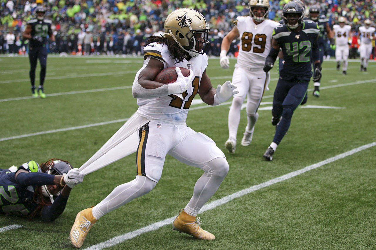 Seattle cornerback Shaquill Griffin grabs a piece of uniform as he tries to stop New Orleans Saints running back Alvin Kamara in the second half of Sunday’s game at CenturyLink Field. (AP Photo/Scott Eklund)
