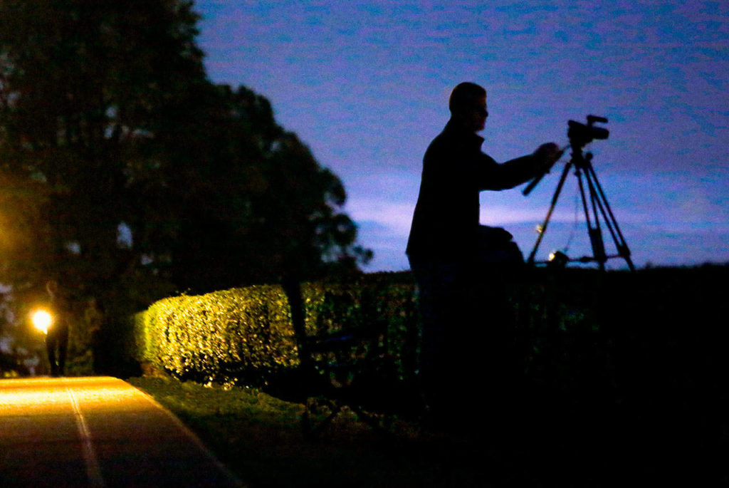 Rodger Griffin, who spent at least 12 hours taking video at the site Wednesday, tends to one of his cameras. It was a great day, he said. (Dan Bates / The Herald)
