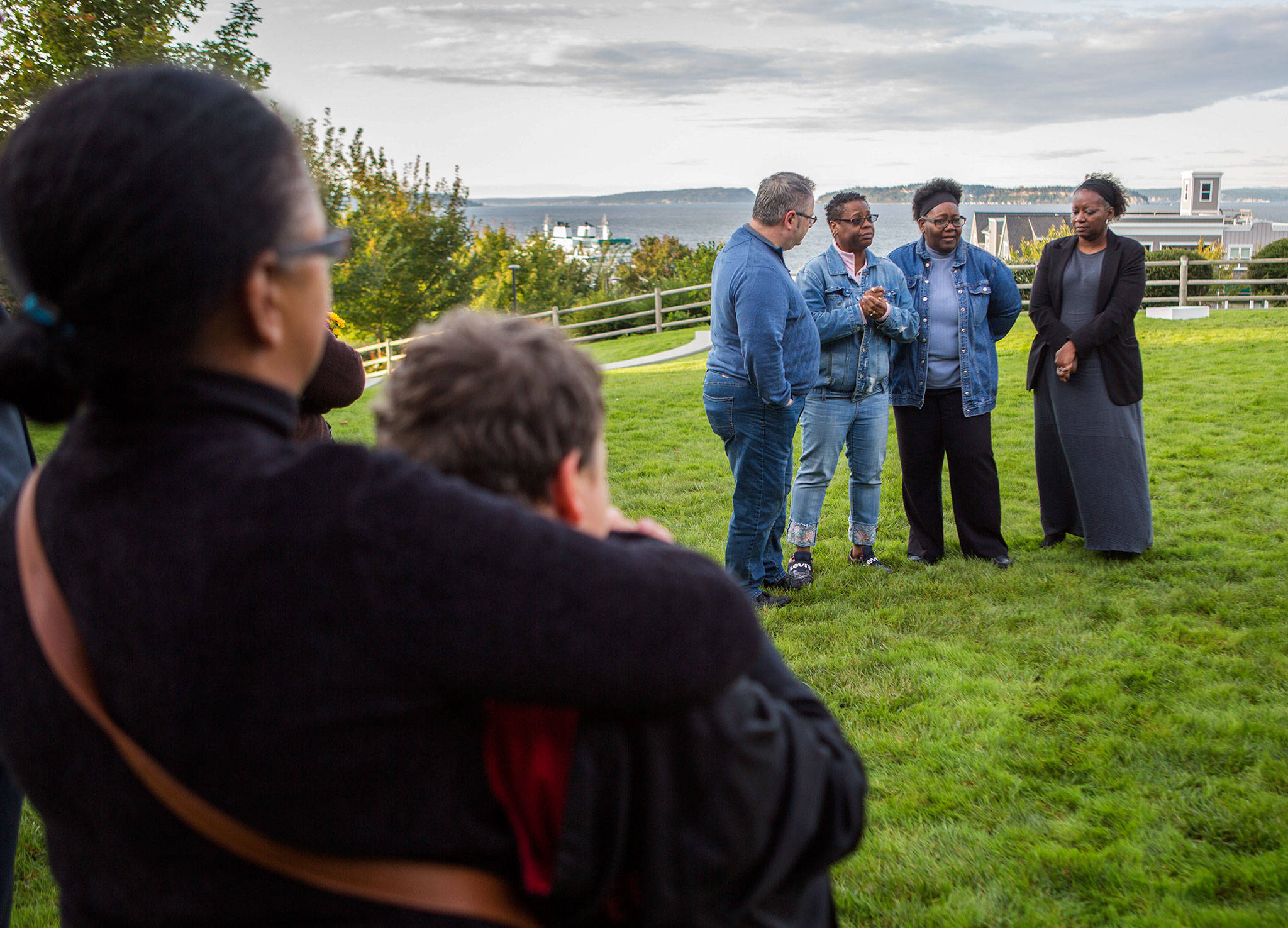 Ann Fields, right, Pam Fields, and LaTonage Kelly speak to a group of family, friends and officials involved in Ezekiel Kelly’s murder case at a bench dedication at the Rosehill Community Center on Saturday in Mukilteo. (Olivia Vanni / The Herald)