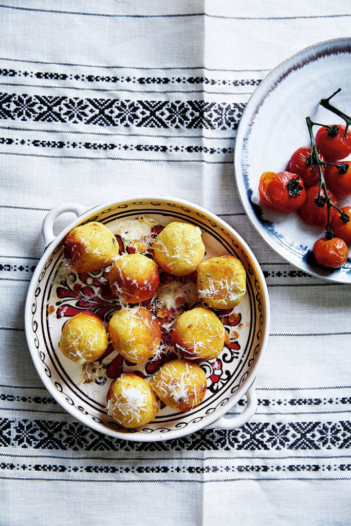 Shepherd’s bulz are bite-sized polenta balls stuffed with melty cheese and served with roasted tomatoes. (Ola O. Smit)
