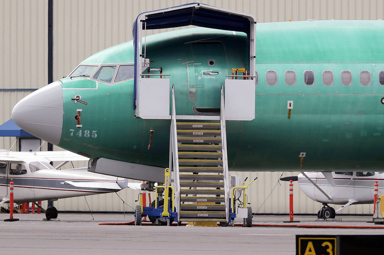 In this April 8 photo, a Boeing 737 MAX 7 jet is parked near single engine planes at the airport adjacent to a Boeing Co. production facility in Renton. (AP Photo/Elaine Thompson, File)
