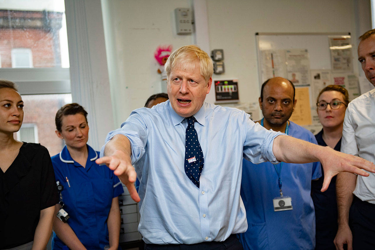 Britain’s Prime Minister Boris Johnson looks on during a visit Sunday to North Manchester General Hospital before the Conservative Conference, in Manchester, England. British Prime Minister Boris Johnson has urged calm as tempers flare in the debate over Britain’s departure from the European Union, even though tempers are flaring over what he said. A defiant Johnson told the BBC on Sunday that the “best thing for the country and for people’s overall psychological health would be to get Brexit done.” (Andy Stenning/Pool Photo via AP)