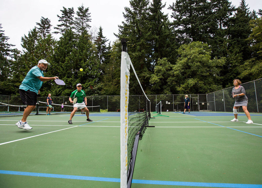 Roger BelAir plays doubles at Yost Park in Edmonds. (Olivia Vanni / The Herald)
