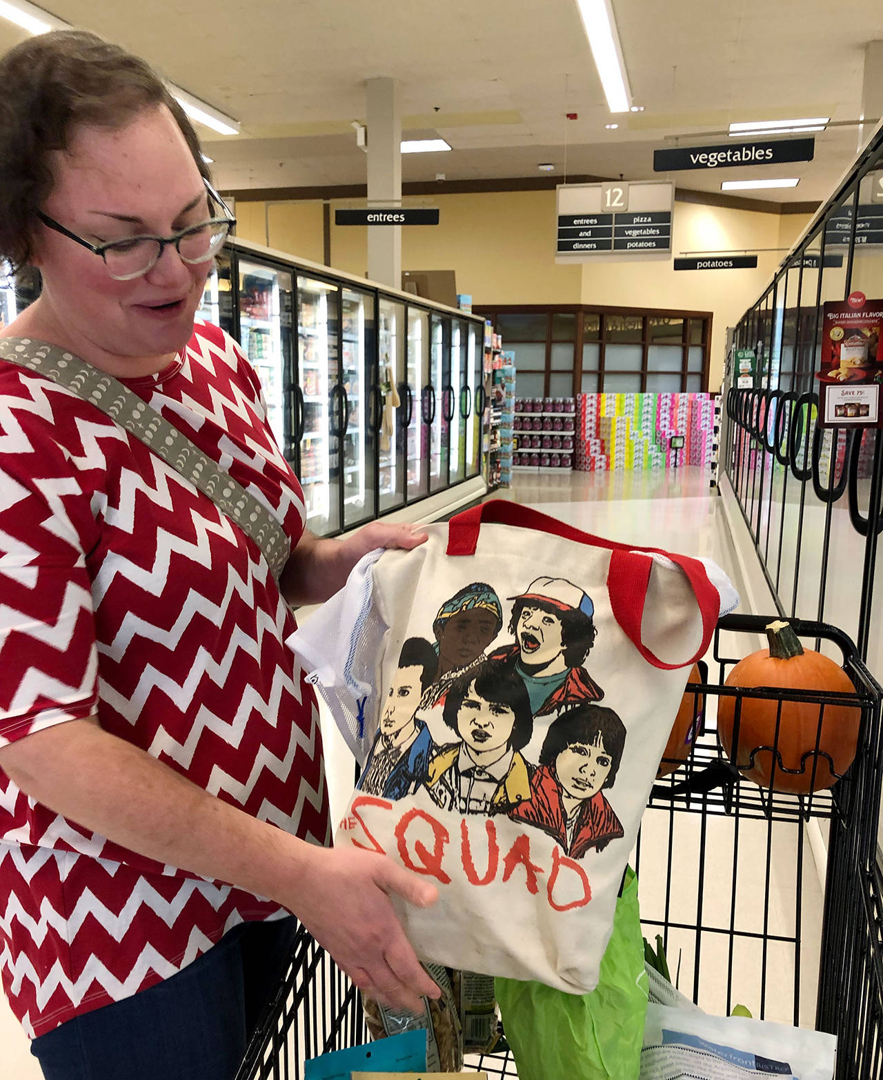 Laura Zorick shows off her “Stranger Things” bag at an Everett grocery store on Monday. She bought it at Funko. (Janice Podsada / The Herald)
