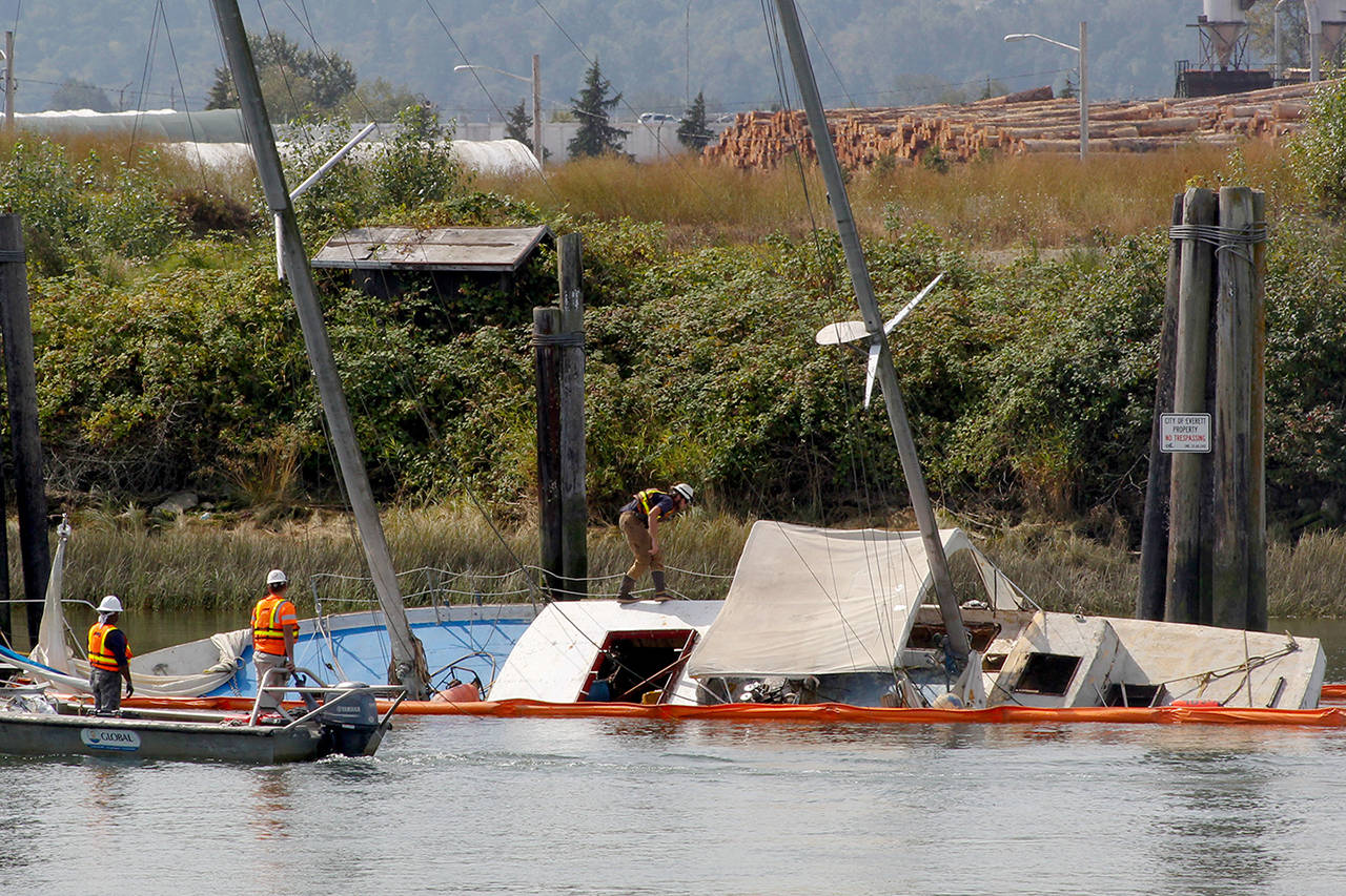 Contractors for the state Department of Ecology investigate a sunken sailboat Aug. 20 on the Snohomish River. Work to remove it could begin Oct. 21. (Joey Thompson /Herald file)