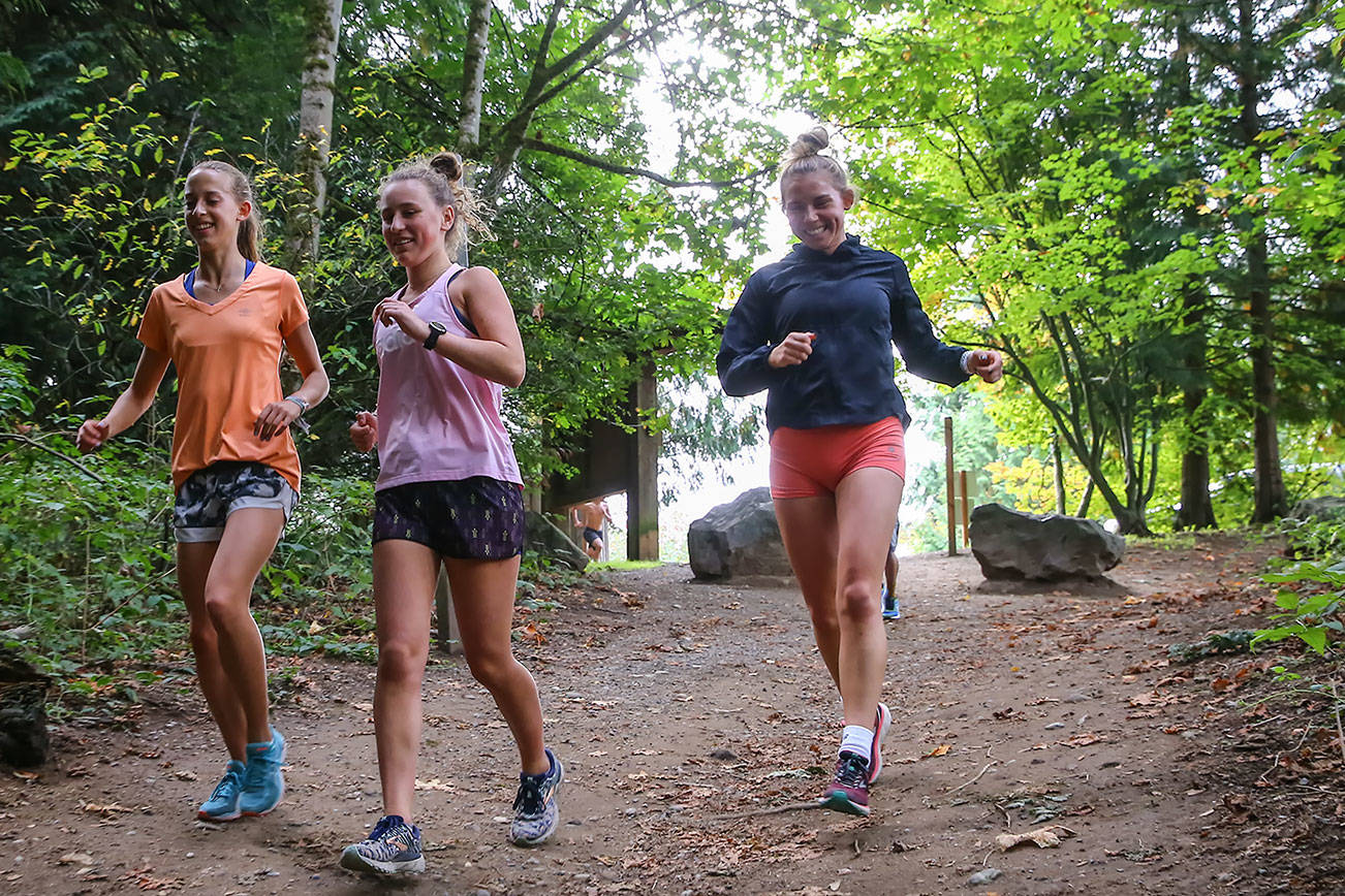 Alexis Palmer (left) and Lindsay Arday shares a laugh during warm-ups before running Wednesday afternoon at Lord Hill Regional Park in Snohomish on October 2, 2019. (Kevin Clark / The Herald)