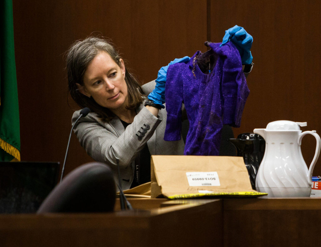 Jane Jorgensen, an investigator for the Snohomish County Medical Examiner’s Office, holds up a sweater found on Phillipa Evans-Lopez’s body. The investigator testified at the trial of Anthony Garver at the Snohomish County Courthouse on Friday, Oct. 4, 2019 in Everett, Wash. (Olivia Vanni / The Herald)
