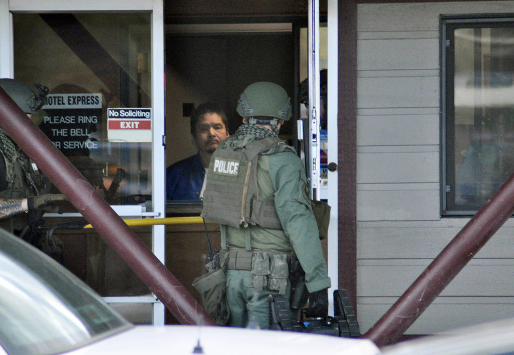 Police enter the Motel Express Thursday morning in response to a robbery report. (Sue Misao / The Herald)
