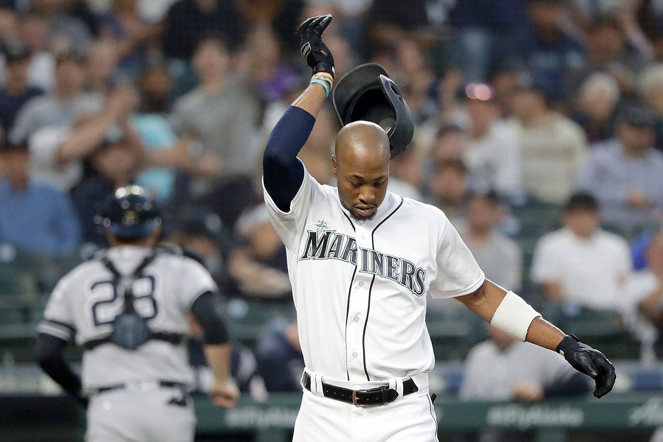 The Seattle Mariners’ Keon Broxton knocks his helmet off after striking out looking as New York Yankees catcher Austin Romine, back left, heads to the dugout in the second inning of a baseball game Monday, Aug. 26, 2019, in Seattle. (AP Photo/Elaine Thompson)