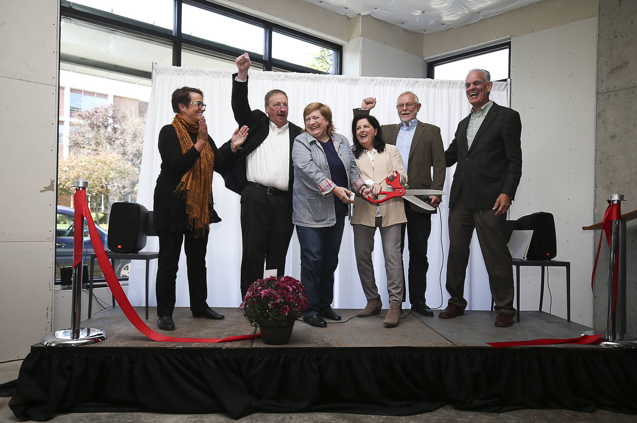 Local leaders cheer after a ribbon is cut at HopeWorks Station on Friday in Everett. The building will have 65 units for families, veterans and young adults. (Andy Bronson / The Herald)