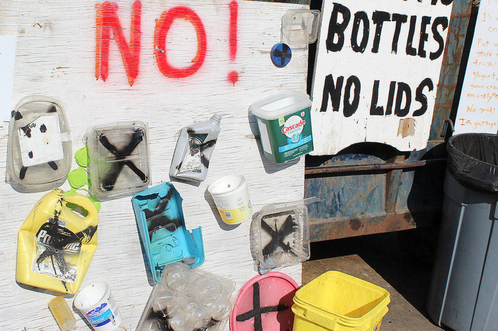 A board displays plastic containers refused at Island Recycling in Freeland. It takes containers marked with the recycling symbol No. and No. 2, which include water, juice and milk and other bottles. (Patricia Guthrie / Whidbey News Group)
