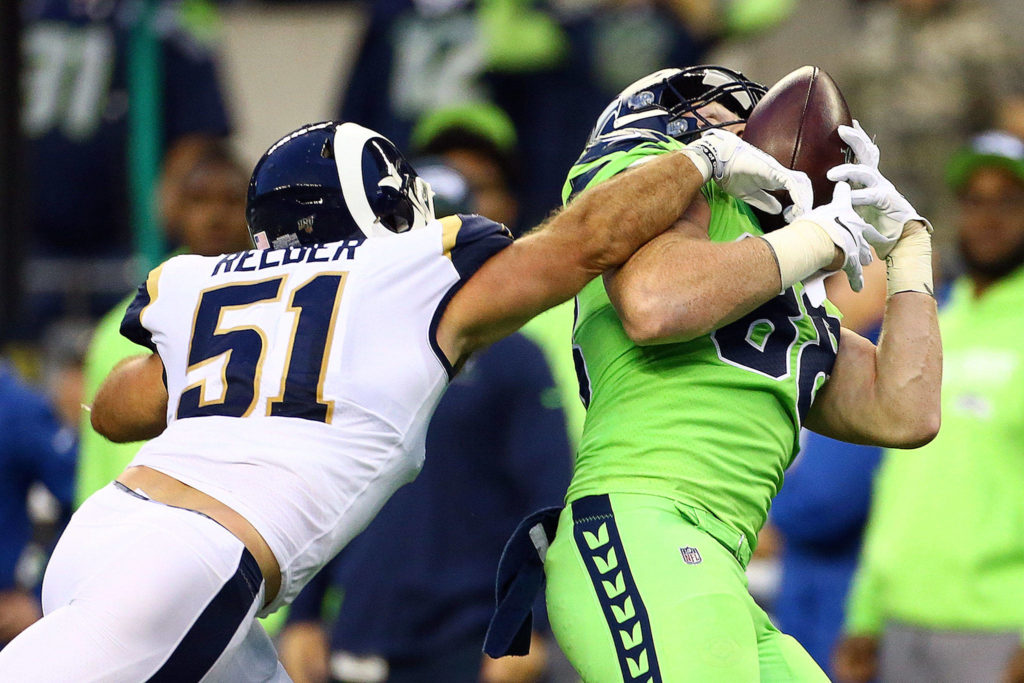 Seattle’s Will Dissly (right) makes a reception over the outstretched arm of Los Angeles’ Troy Reeder during the Seahawks’ 30-29 win over the Rams Thursday at CenturyLink Field in Seattle. (Kevin Clark / The Herald)
