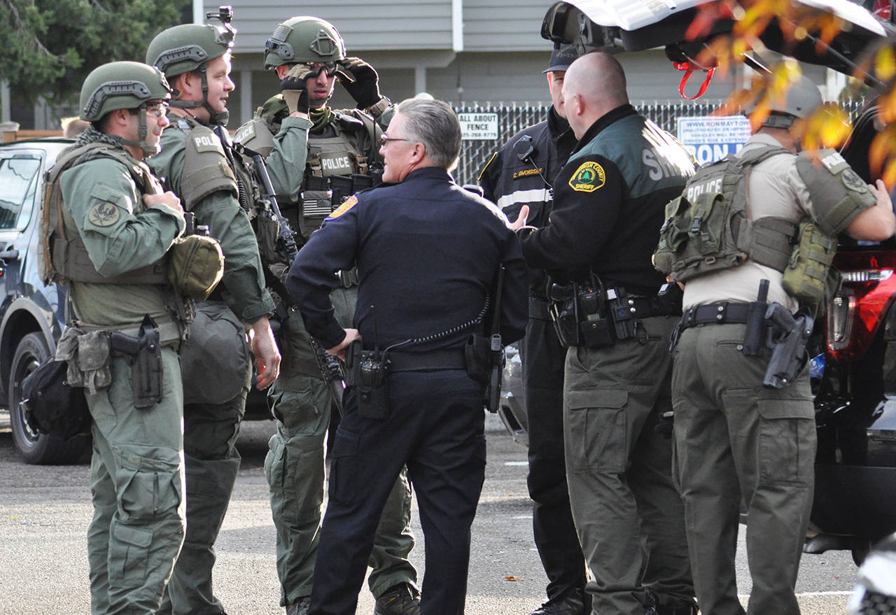 Law enforcement stage at the Alfys Pizza parking lot after an armed robbery suspect was holed up in the Motel Express in Everett on Thursday morning. (Sue Misao / The Herald)