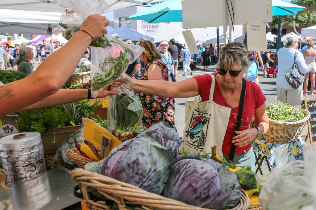 Nancy Cody shops at a produce stand this summer at the Everett Farmers Market. (Kevin Clark / Herald file)
